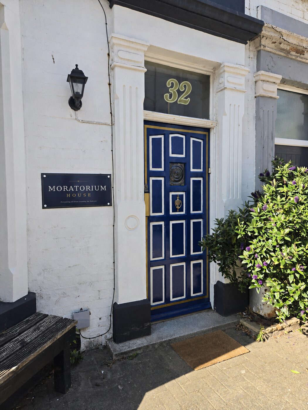 The blue front door of number 32 with the Moratorium House plaque