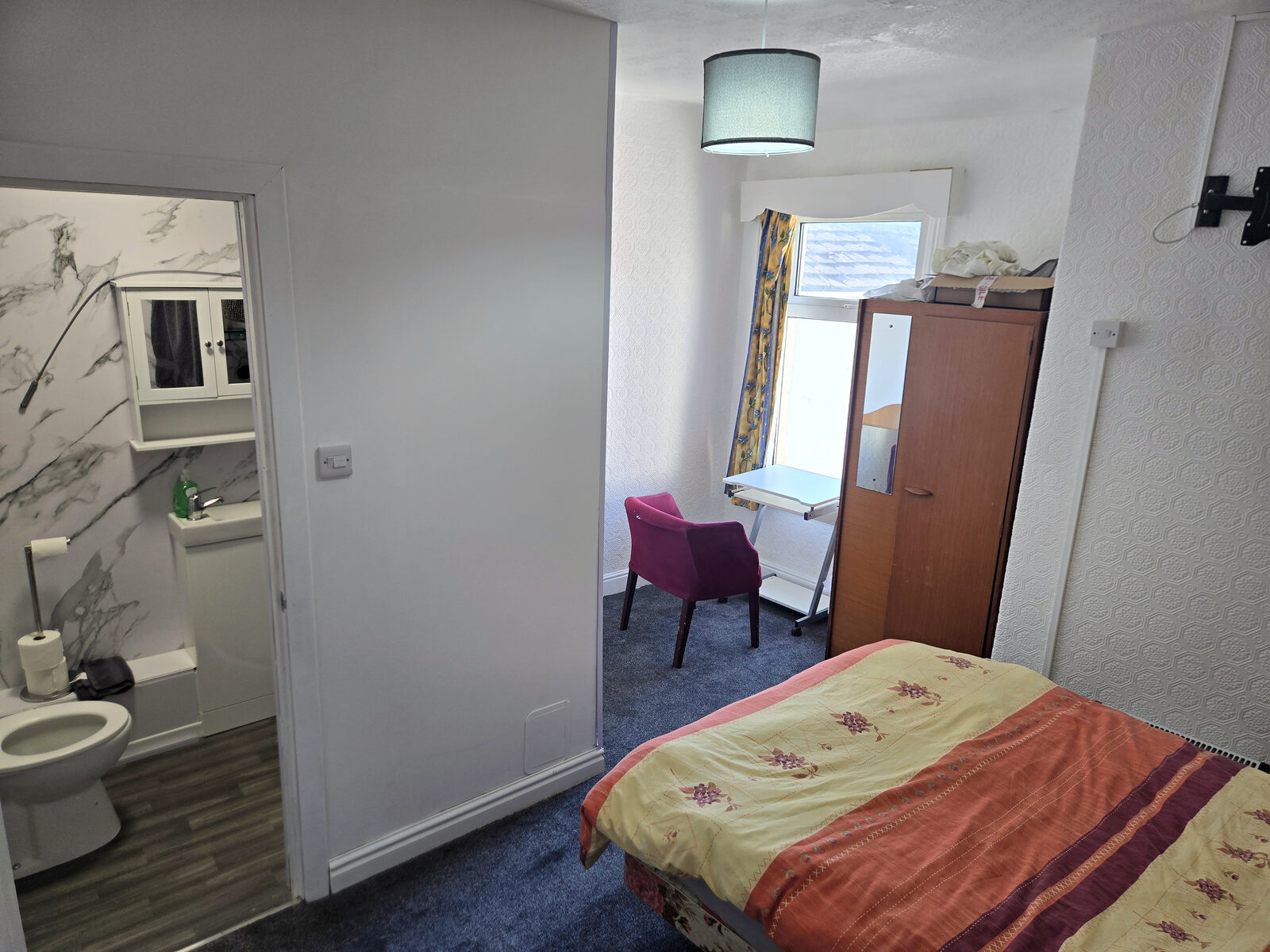 A bedroom with its own private bathroom off it