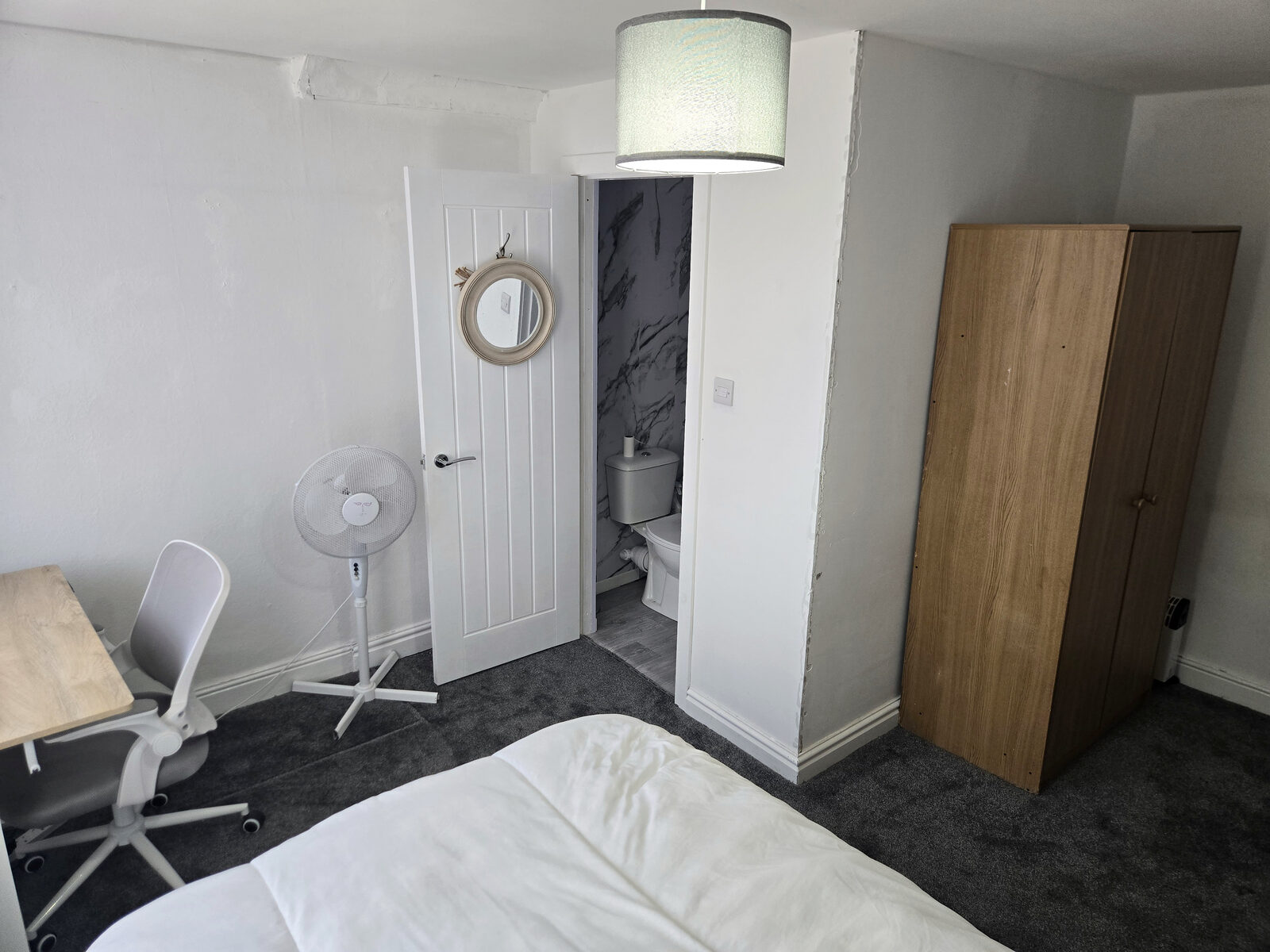 An en suite bedroom with a double bed, desk and wardrobe